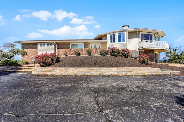 view of front of property with central AC and a balcony