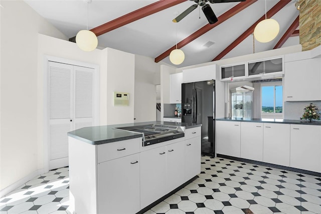 kitchen featuring pendant lighting, electric stovetop, beamed ceiling, and a kitchen island