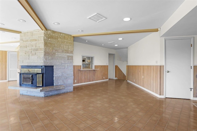 unfurnished living room with beam ceiling, tile patterned floors, and wooden walls