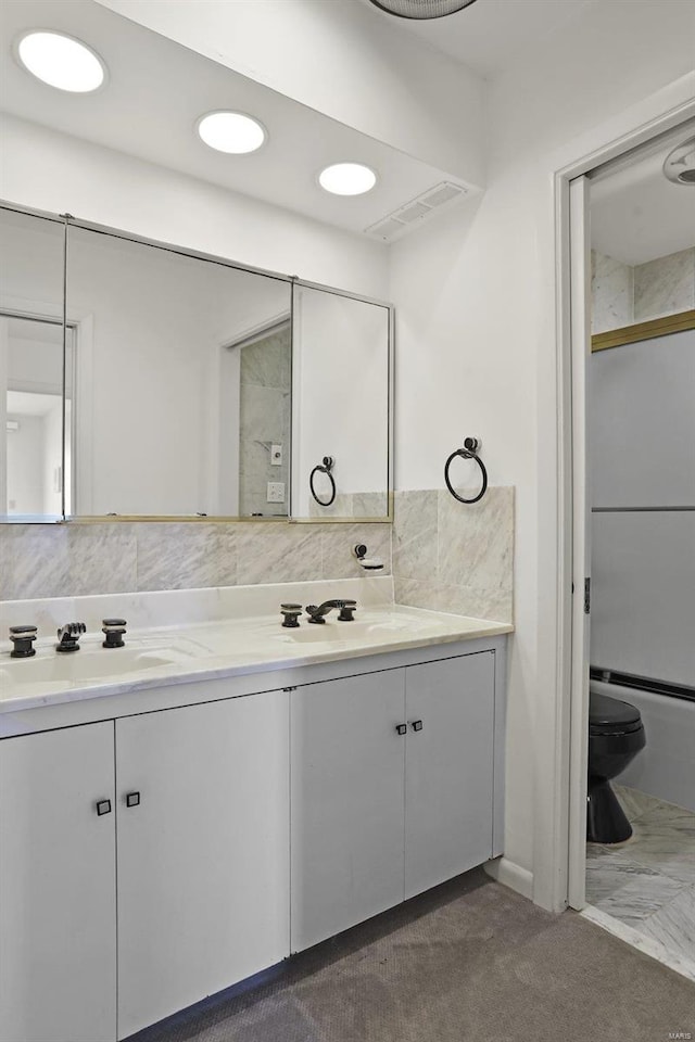 full bathroom featuring vanity, toilet, and combined bath / shower with glass door