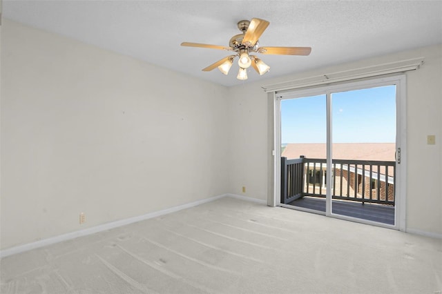 spare room with ceiling fan, light colored carpet, a water view, and a textured ceiling