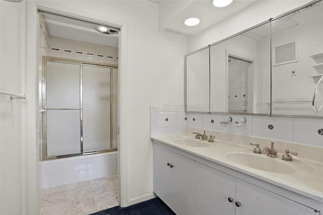 bathroom featuring tasteful backsplash, vanity, and shower / bath combination with glass door