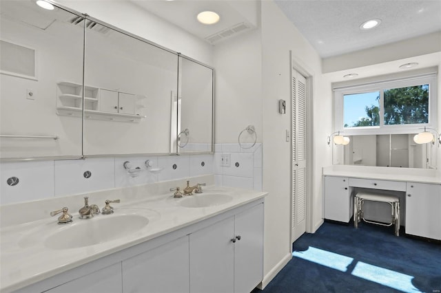 bathroom featuring decorative backsplash, vanity, and a textured ceiling