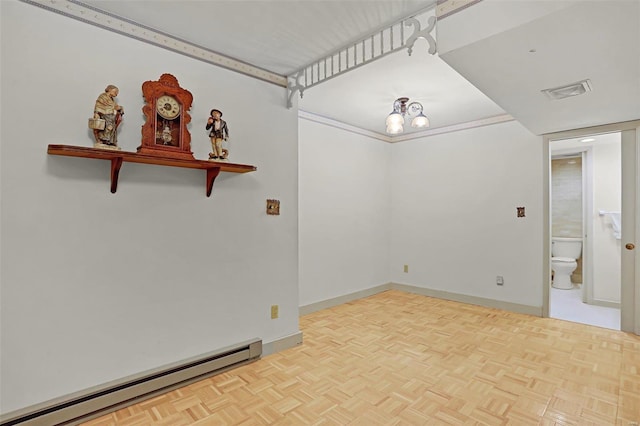 spare room featuring a baseboard heating unit and light parquet floors