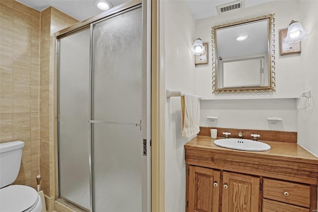 bathroom with vanity, an enclosed shower, and toilet