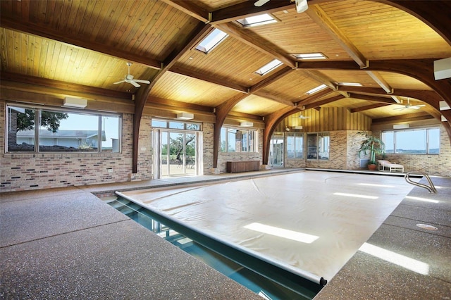 view of swimming pool featuring ceiling fan, a skylight, and an indoor hot tub