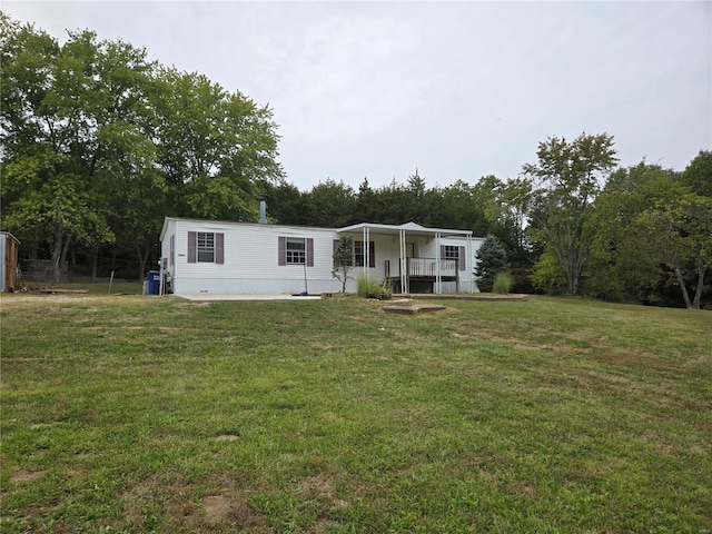 rear view of property featuring a yard and a porch