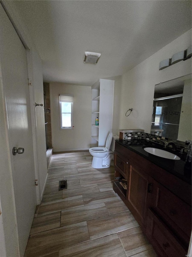 bathroom with a textured ceiling, a shower, vanity, and toilet