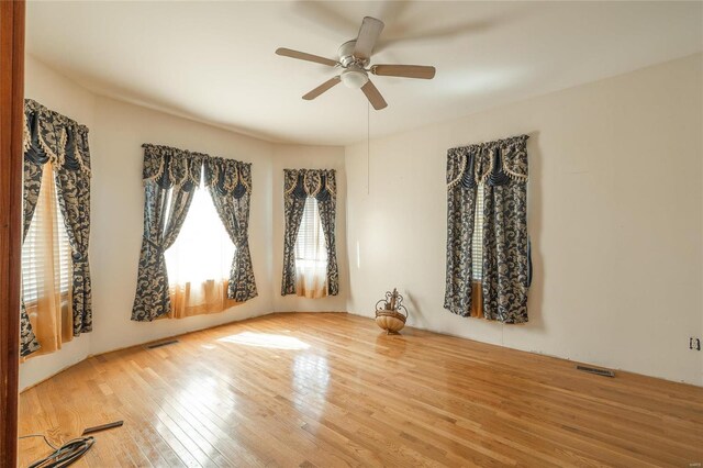 empty room with hardwood / wood-style floors and ceiling fan