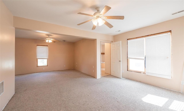 spare room with ceiling fan and light colored carpet