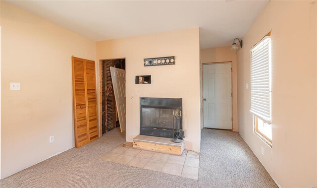 unfurnished living room featuring a wealth of natural light and light colored carpet