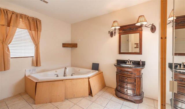 bathroom featuring tile patterned flooring, a tub to relax in, and vanity