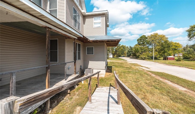 exterior space featuring a lawn and central AC