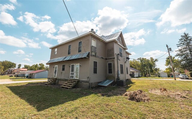 view of side of property featuring a yard and central air condition unit