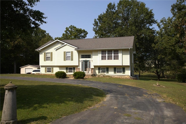 bi-level home with an outdoor structure and a front yard