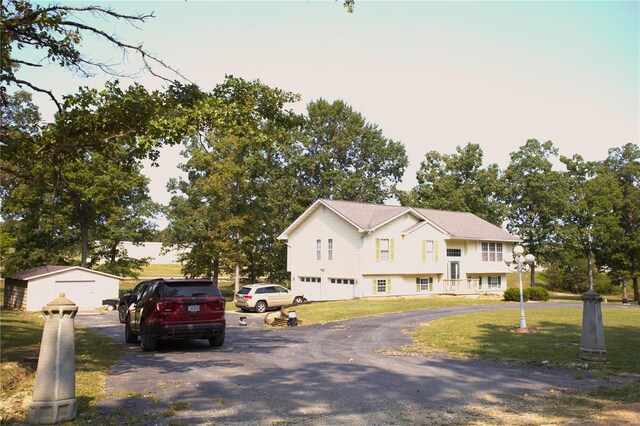 raised ranch featuring a lawn and a garage