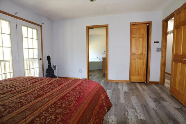 bedroom featuring connected bathroom and hardwood / wood-style flooring