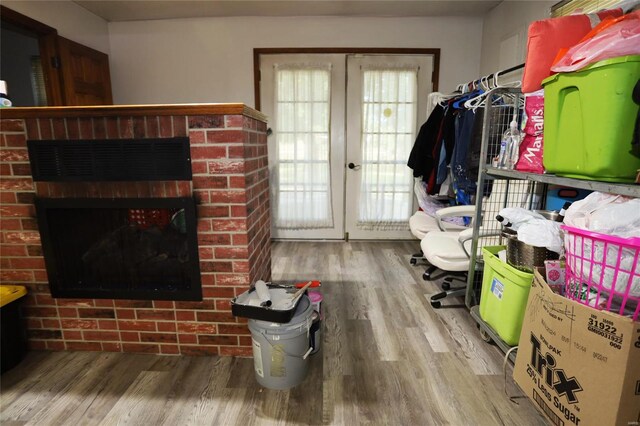 interior space featuring french doors, wood-type flooring, and a fireplace