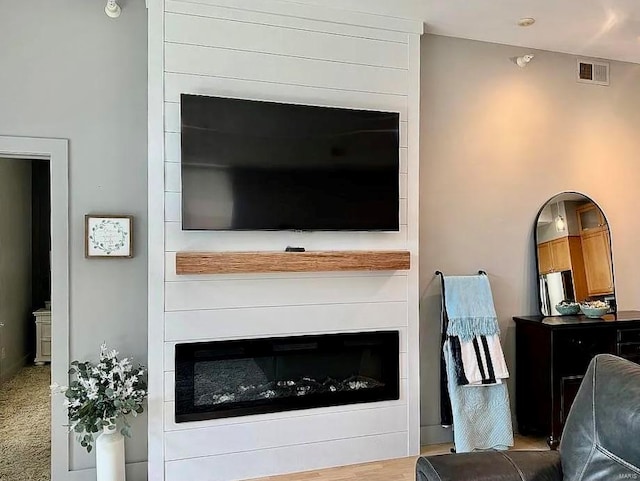 carpeted living room with a large fireplace