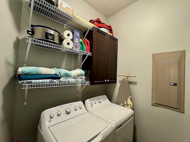 laundry area featuring electric panel, cabinets, and washing machine and clothes dryer