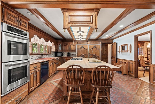 kitchen featuring a kitchen island with sink, sink, tasteful backsplash, stainless steel appliances, and ornamental molding