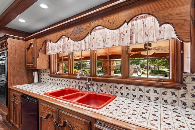 kitchen featuring decorative backsplash, dishwasher, ceiling fan, and sink