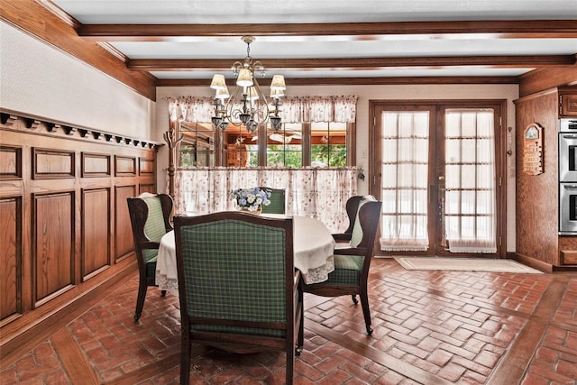 dining area with beamed ceiling and a chandelier