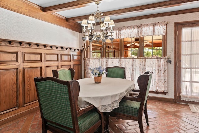 dining space with beamed ceiling, a chandelier, and a wealth of natural light