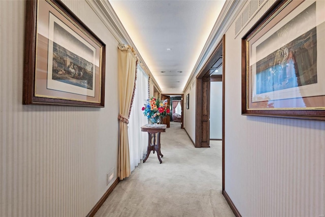 hallway featuring crown molding and light colored carpet