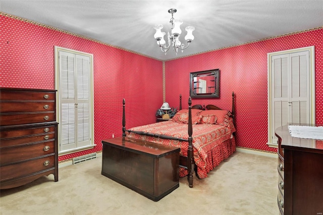 bedroom with a textured ceiling, an inviting chandelier, and light colored carpet