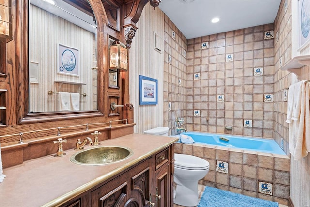 bathroom featuring vanity, a relaxing tiled tub, and toilet