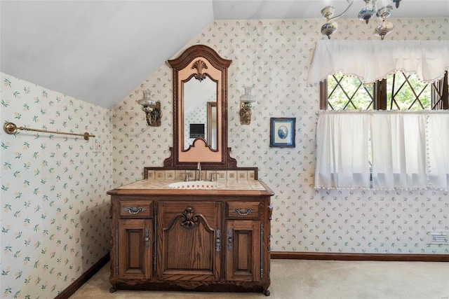 bathroom with vaulted ceiling and vanity