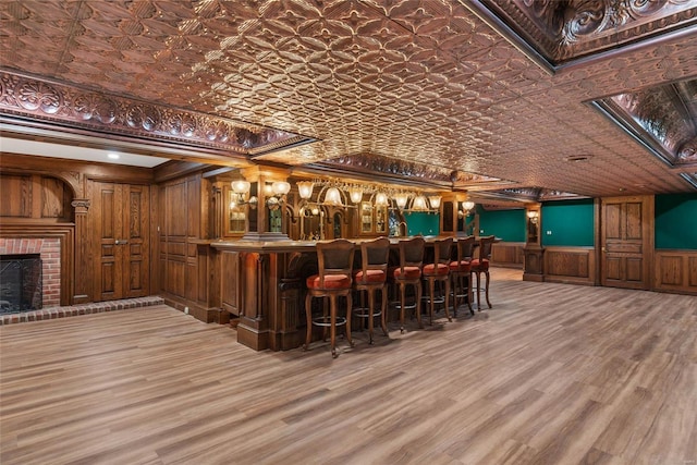 bar featuring hardwood / wood-style floors, a fireplace, and crown molding