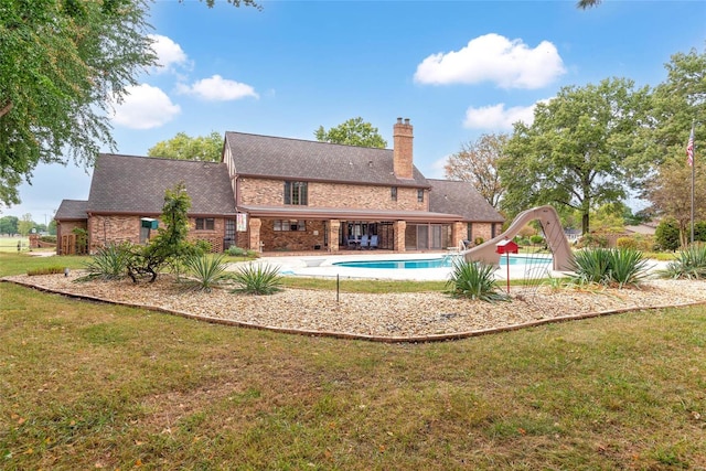 back of property with a lawn and a patio area