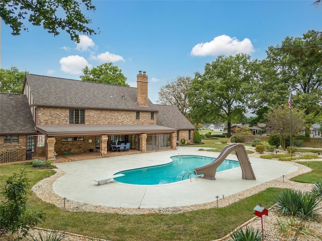 view of pool with a patio, a diving board, and a water slide