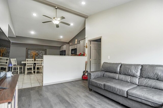 living room featuring light wood-type flooring, ceiling fan, and high vaulted ceiling