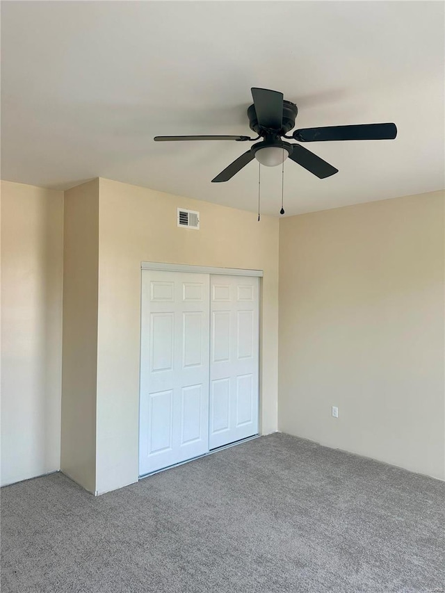 unfurnished bedroom with carpet, ceiling fan, and a closet