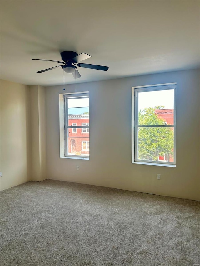 carpeted spare room featuring ceiling fan