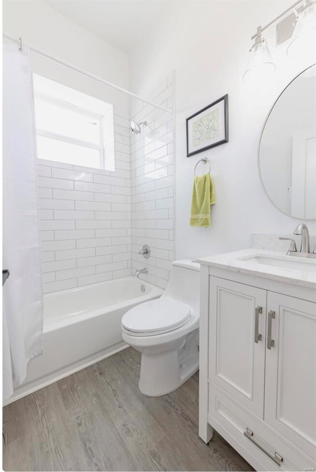 full bathroom with vanity, toilet, hardwood / wood-style floors, and shower / bath combination with curtain