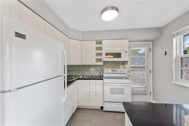 kitchen featuring white appliances, white cabinetry, light tile patterned floors, and backsplash