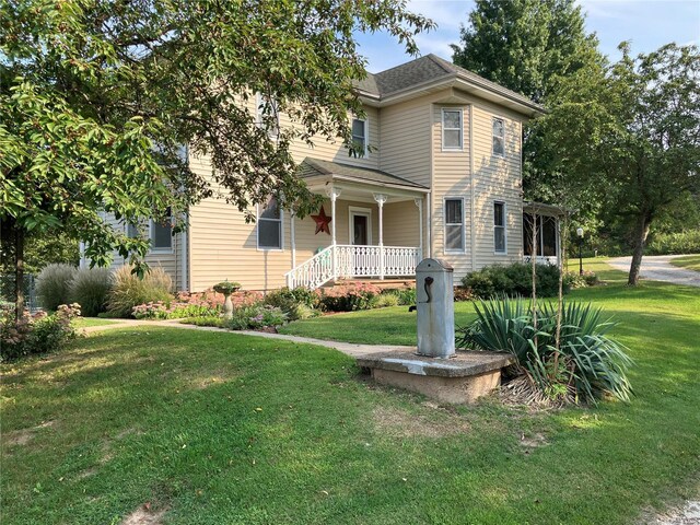 view of front of house with a front yard and a porch