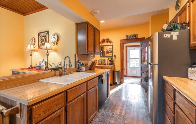 kitchen featuring dishwasher, dark hardwood / wood-style floors, sink, stainless steel refrigerator, and backsplash