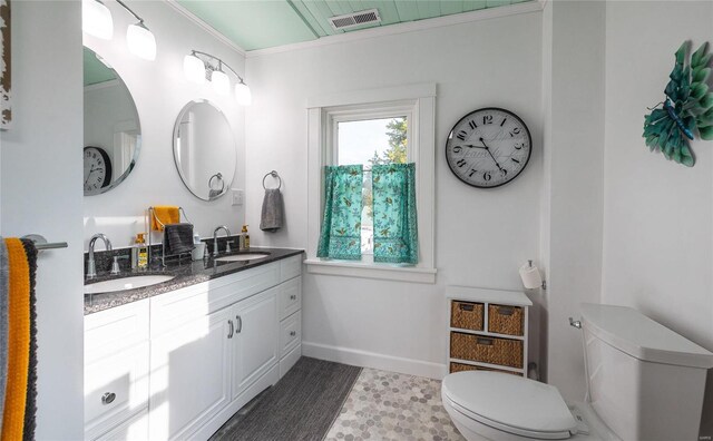 bathroom featuring wood-type flooring, vanity, crown molding, and toilet