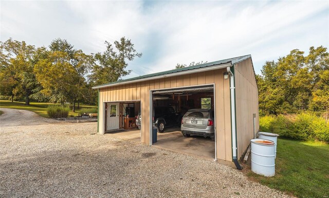 garage featuring a lawn and wooden walls