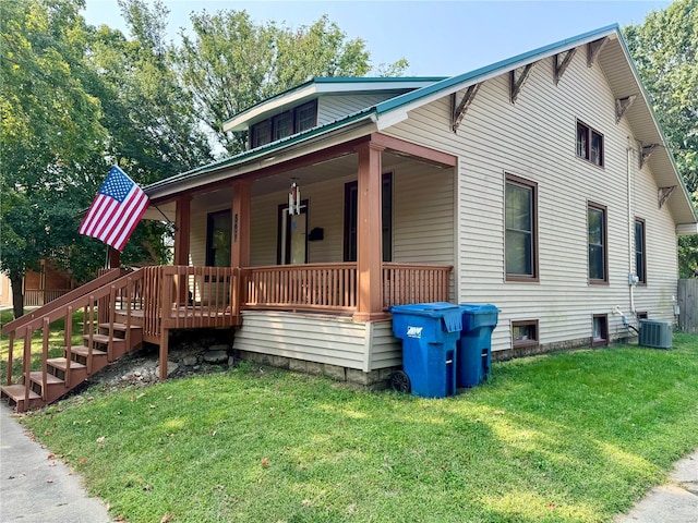 view of front of property featuring a front lawn, covered porch, and central AC