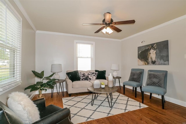 living room featuring wood-type flooring, crown molding, and ceiling fan