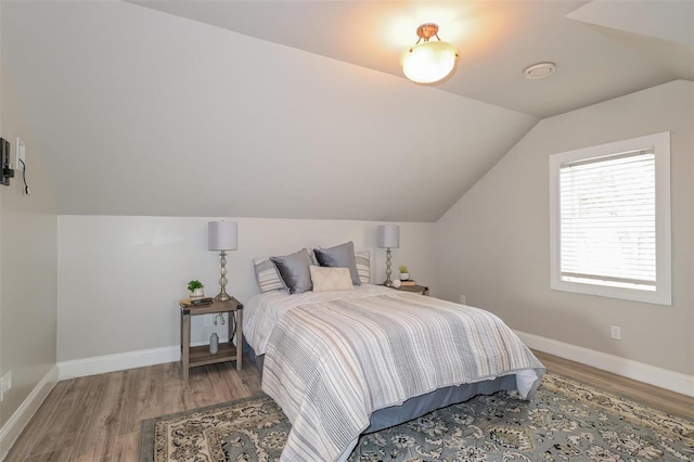 bedroom with vaulted ceiling and wood-type flooring