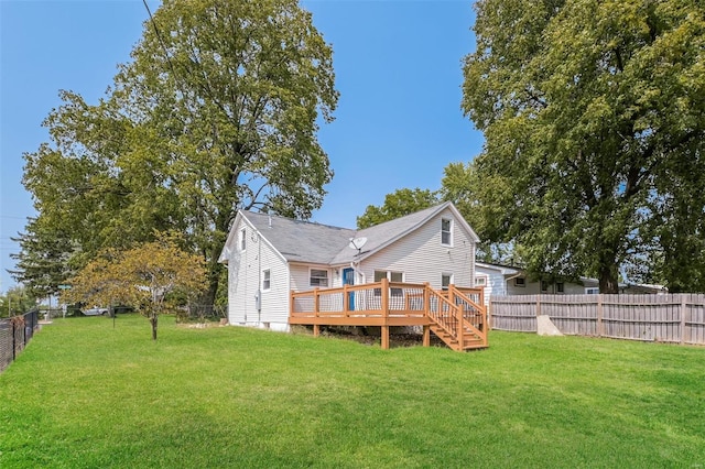 rear view of house featuring a lawn and a wooden deck