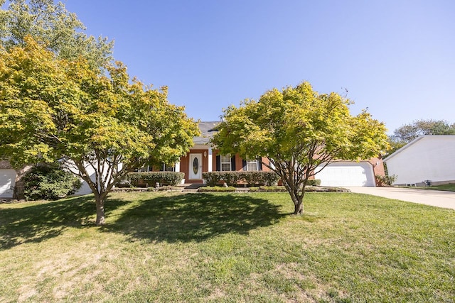 view of property hidden behind natural elements with a front lawn and a garage