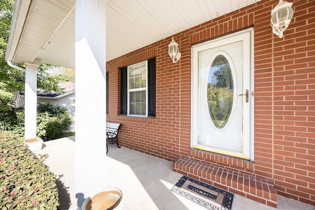 view of exterior entry featuring covered porch